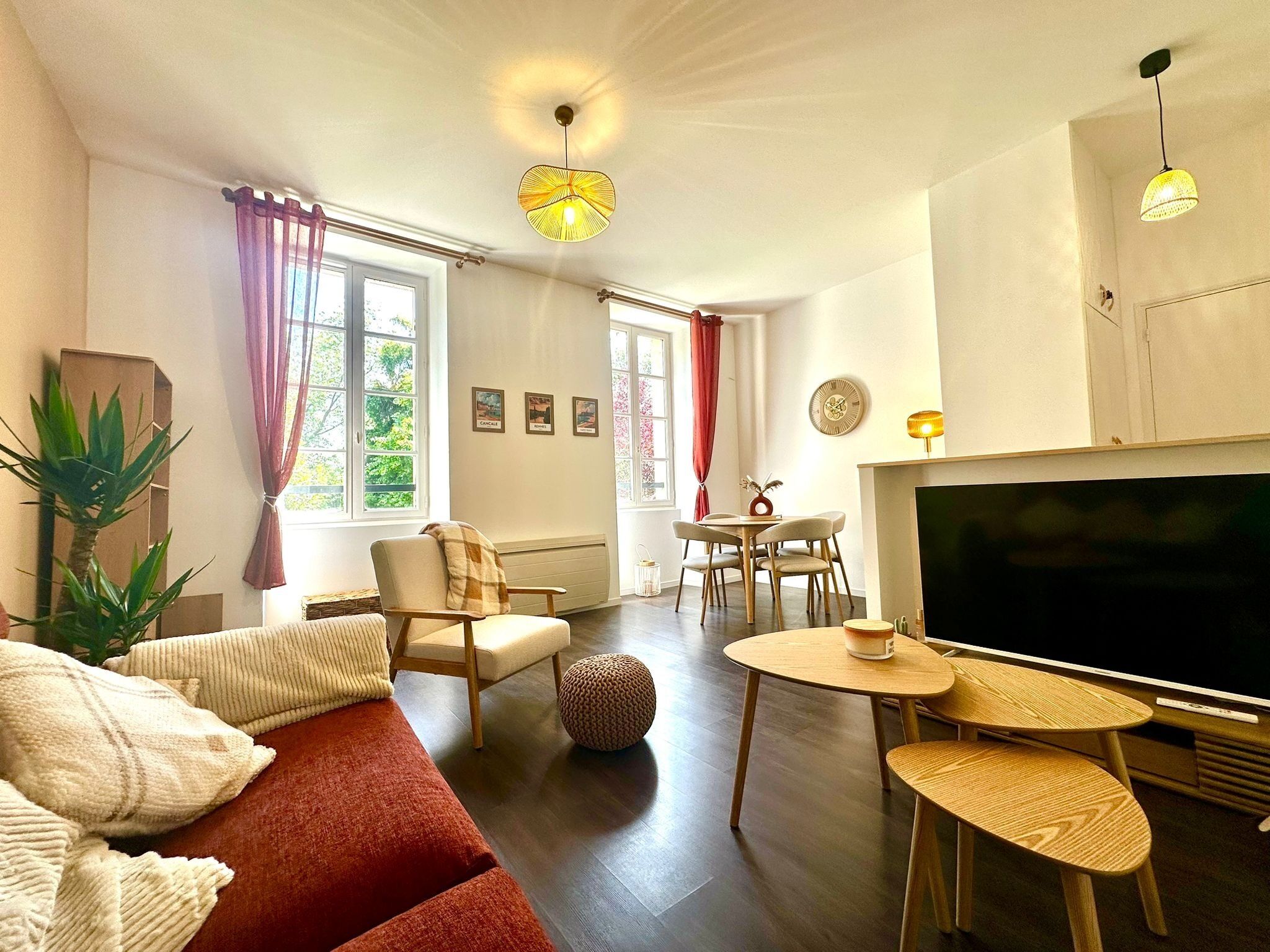 Un salon comprenant un canapé, un téléviseur, une table à manger et une cheminée.. Le manoir Mermoz - Havre de paix à Rennes