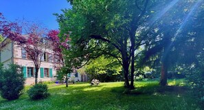Un bâtiment doté d’un jardin, d’arbres et surplombant un ciel dégagé.