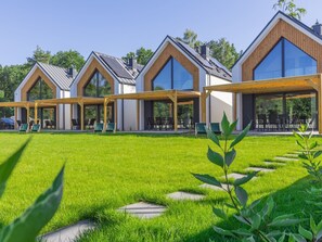 Ein modernes Haus mit großen Fenstern und einer überdachten Terrasse.