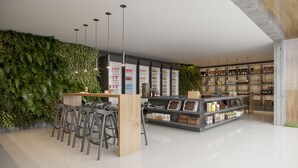 A modern interior with a bar area, seating, and shelves stocked with various products.