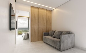 Una sala de estar moderna con un sofá gris, un panel de pared de madera y un gran ventanal con vistas.