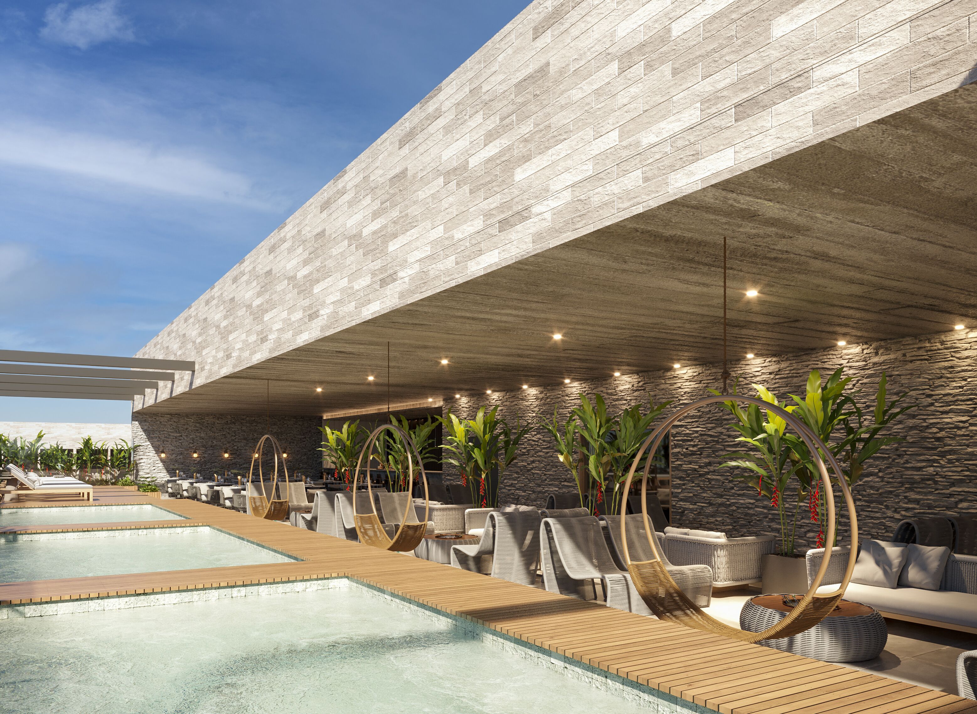 A modern pool area with lounge chairs and a stone wall.