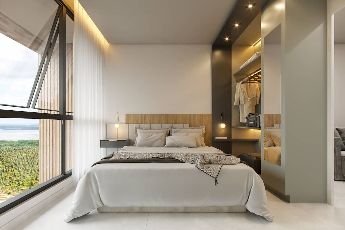 A modern bedroom with a large window, a bed with a headboard, bedside tables, and a built-in closet with a mirror.