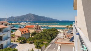 Une vue sur la côte, avec des bâtiments, une marina et une montagne en arrière-plan.