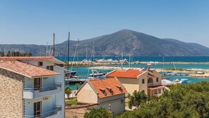 A coastal residential area with houses, a marina, and a mountain in the background.