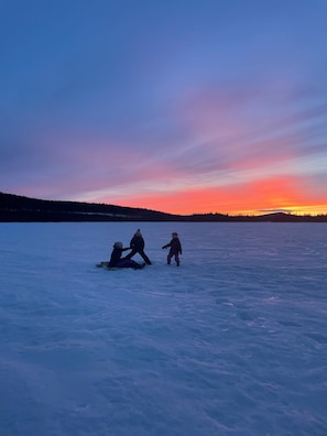 Et sneklædt landskab i solnedgang.