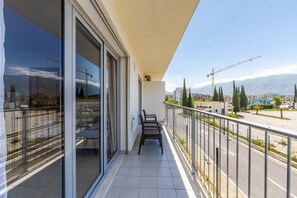 A balcony with a view of a construction site, a road, and distant mountains. - Orikum Beachside Retreat | Apartment 3 by PikHost (Orikum)