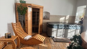 Ein Saunabereich mit Holzbänken, einer Massageliege und einem Dampfbad.