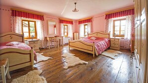 Ein Schlafzimmer mit zwei Betten, einem Schreibtisch, einer Kommode und einem Spiegel.