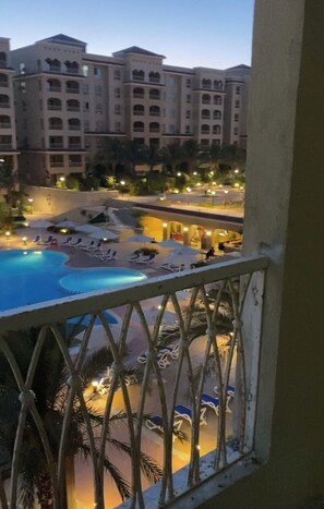 A hotel with a swimming pool, lounge chairs, and palm trees. - شاليه عائلي فاخر في AquaView أكوافيو (elhammam)