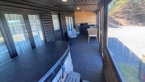 A covered outdoor area with a counter, chairs, and a grill. - Oceanfront Boutique Retreat~Hot Tub~Woodstove (Hearts Delight-Islington)