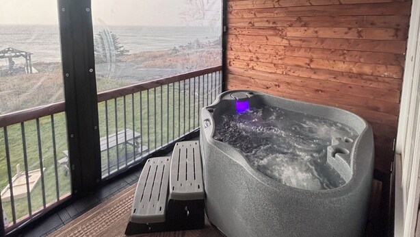 A hot tub on a balcony with a view of the sea. - Oceanfront Boutique Retreat~Hot Tub~Woodstove (Hearts Delight-Islington)
