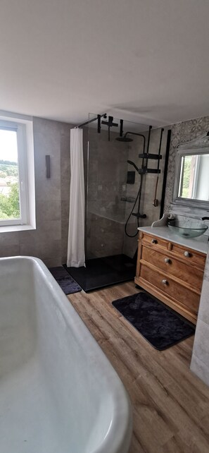 A bathroom with a bathtub, shower, vanity, and a window. - Renovated farmhouse from 1791 with a hot tub; pets welcome; near Alsace (Provenchères-et-Colroy)