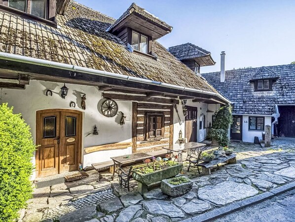 A traditional building with a stone facade, wooden doors, and a cobblestone courtyard.