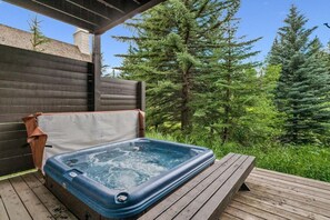 A hot tub on a wooden deck with a wooden fence and trees in the background. - Private Ski-out Village Home in Vail with Hot Tub (Vail)