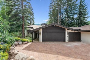 A modern two-story house with a covered patio, a garage, and a driveway. - Private Ski-out Village Home in Vail with Hot Tub (Vail)