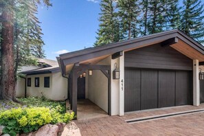 A modern house with a covered garage, a brick driveway, and a well-maintained garden. - Private Ski-out Village Home in Vail with Hot Tub (Vail)