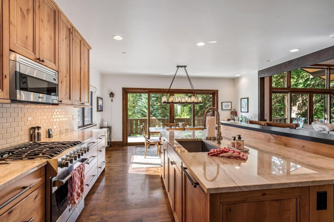 A spacious kitchen with wooden cabinets, a large island, and a view of the outdoors.