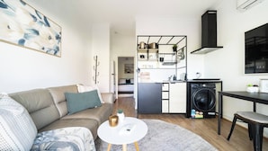 A modern apartment with a living room, kitchenette, and laundry area. - Warrina Nook A Cosy Bushland Escape for Two (Chatswood West)