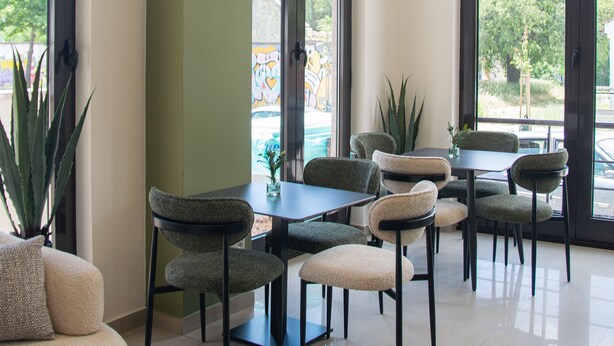 A modern interior with a dining area, chairs, a table, and a large window. - Mostay Boutique Hotel (Mostar)