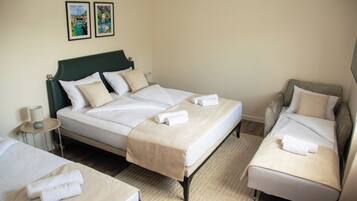 A hotel room with a bed, a sofa, and a small table.