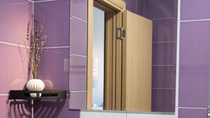 A bathroom with purple tiles, a white sink, a mirror, and a wooden door. - Mostay Boutique Hotel (Mostar)