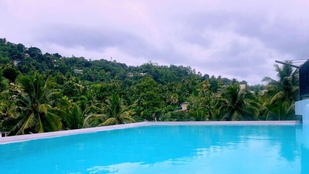 A swimming pool with a view of a lush green hillside. - Ceylon Ayu Resort - Kandy (Kandy)