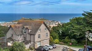 A coastal town with a prominent building featuring a tiled roof and multiple windows. - Lovely apartment for 4 guests with WIFI (St Ives)