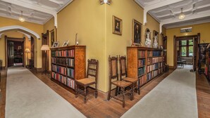 Une bibliothèque avec des étagères, des chaises en bois et un sol recouvert de moquette.