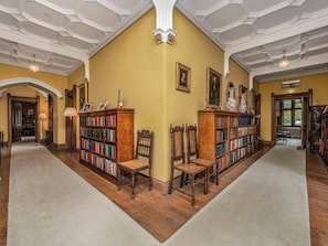 Une bibliothèque avec des étagères, des chaises en bois et un sol recouvert de moquette.