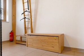 Una habitación con un escritorio de madera, una escalera y un extintor.