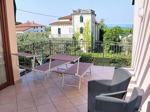 Ein Balkon mit Blick auf ein Gebäude, ein Stuhl und ein Tisch.