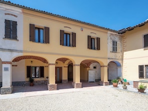 A building with multiple arches, a tiled roof, and potted plants. - Wonderful  villa for 5 guests with WIFI, private pool, patio, pets allowed and panoramic view (Asti)