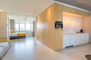 Un intérieur moderne comprenant une cuisine et une chambre.