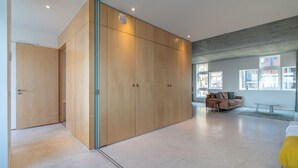 Una habitación amplia con un armario grande, un sofá y una ventana que proporciona luz natural.