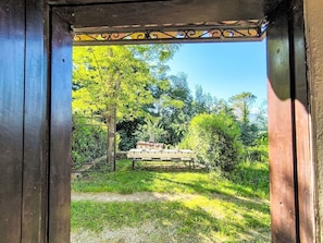 Ein Durchgang zu einem Garten mit Tisch und Stühlen.