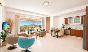 A modern apartment with a balcony, a dining area, and a kitchen. - Olive Green Villa Heated Pool (Agios Nokolaos)