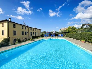 Une piscine rectangulaire à l’eau d’un bleu limpide, entourée d’une terrasse dallée.