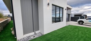 A modern house with a white exterior, a grey door, and a garage.