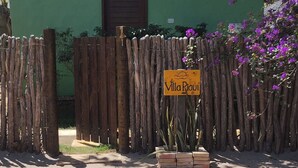 A wooden fence with a sign reading 'Villa Piavi' in front of a green building.