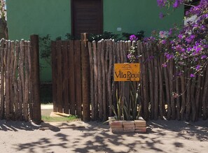 A wooden fence with a sign reading 'Villa Piavi' in front of a green building. - Premium Rustic-Tropical Suite: Charm, Balcony, Hammock and Nature (Cajueiro da Praia)