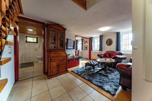 Un salon spacieux avec un grand meuble en bois, une cheminée et un coin salon confortable.