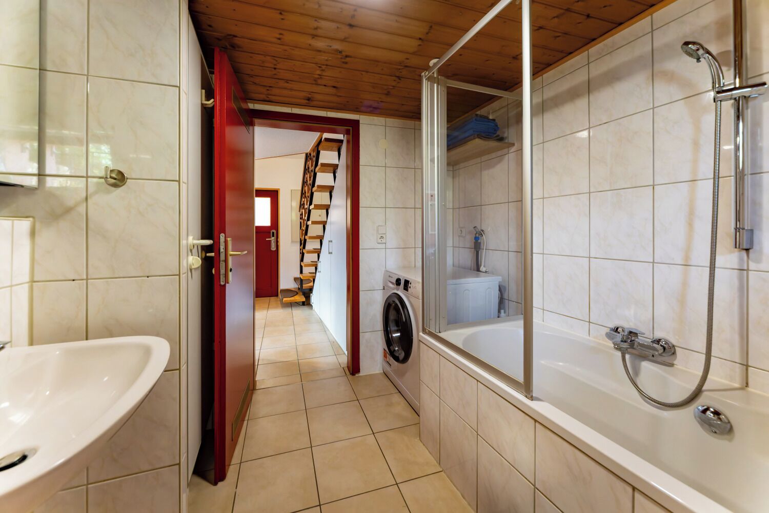 Ein Badezimmer mit Waschbecken, Waschmaschine und Badewanne.