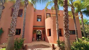 Un edificio con fachada curva, múltiples ventanas y una entrada central con arco.