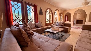 A spacious living room with a sofa set, a coffee table, and a fireplace. - Villa Amazura 6 Bedroom with Private Pool (Marrakech)