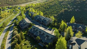 Ett bostadsområde med hus, en väg och en bro i bakgrunden.
