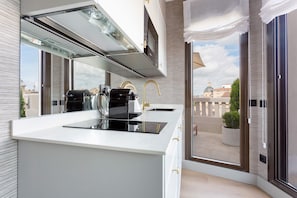 Una cocina moderna con estufa integrada, un lavamanos y un ventanal con vistas a la ciudad.