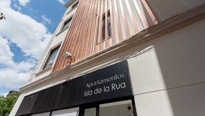 Un edificio con un cartello che riporta 'Apartamentos Isla de la Rúa'.