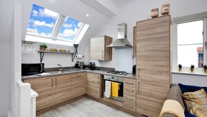 A modern kitchen with wooden cabinets, a built-in oven, a microwave, and a gas stove. - Captains Retreat, Whitby (Whitby)