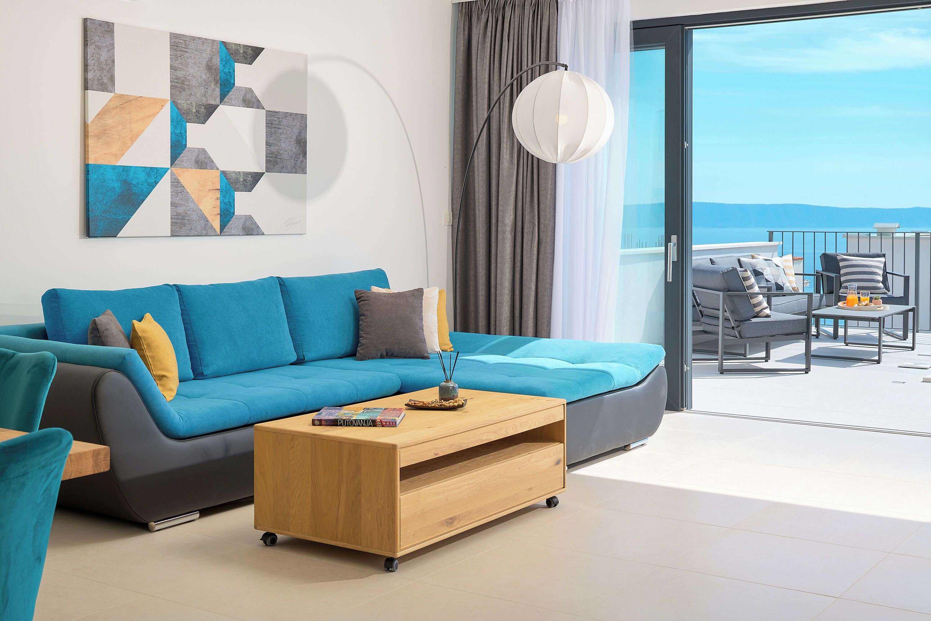 Sala de estar moderna com sofá, mesa de centro e vista para a varanda.
